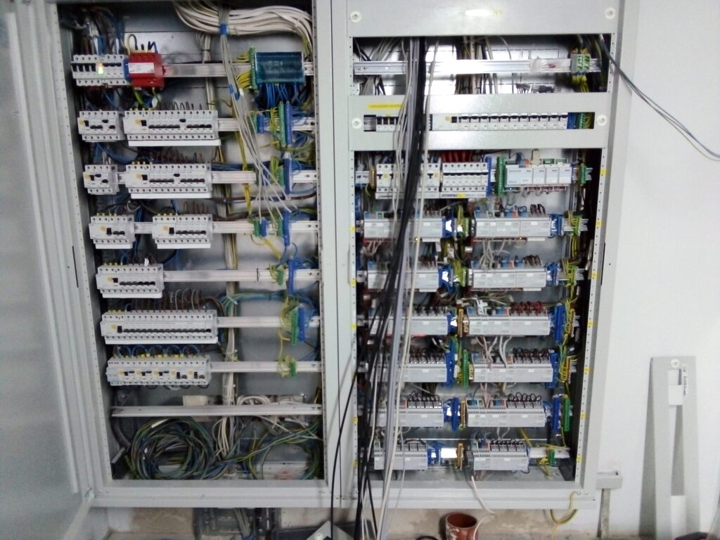 Skrzynka rozdzielcza z kablami i przełącznikami.